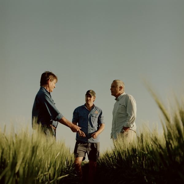 Three men talking in a field