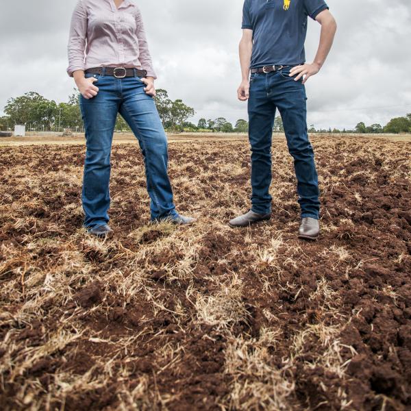 Two young students standing in a fallow paddock