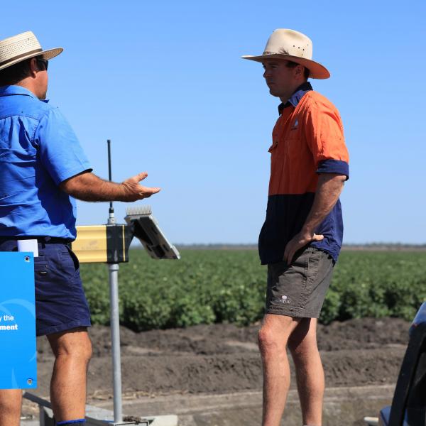 Two men talking in a field