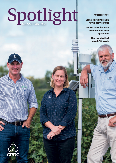 Two men and a woman standing in a cotton paddock with a weather station tower.